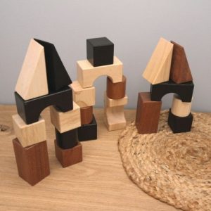 houten bouwblokken met verschillende vormen en kleuren op plank met grijze achtergrond
