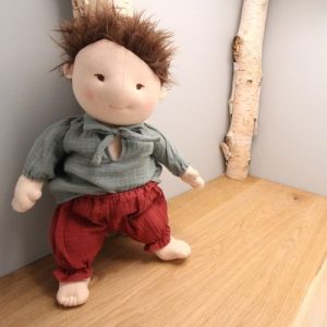 broek rood gedragen door pop victor op hout met grijze achtergrond